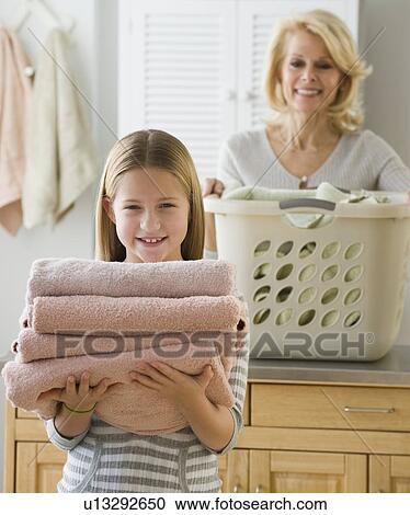 Girl holding stack of folded towels View Large Photo Image Stock Image - Girl holding stack of folded towels. Fotosearch