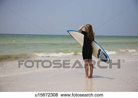 Stock Photo - Girl holding surfboard, Florida, United States. Fotosearch