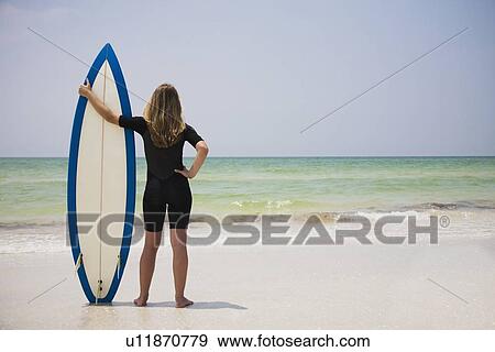 Girl holding surfboard in sand, Florida, United States View Large Photo Image Stock Photo - Girl holding surfboard in sand, Florida, United States. Fotosearch