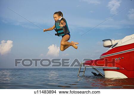 Girl in lifejacket jumping off boat, Florida, United States View Large Photo Image Picture - Girl in lifejacket jumping off boat, Florida, United States. Fotosearch