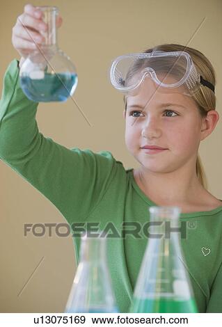 Stock Photo - Girl in science class looking at beaker. Fotosearch