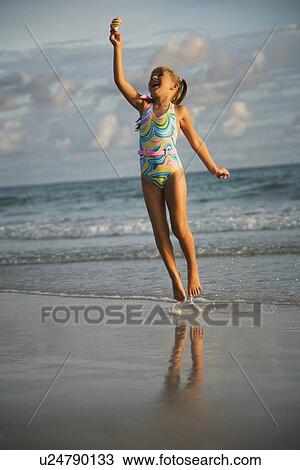 Girl jumping in ocean surf, Florida, United States View Large Photo Image Stock Image - Girl jumping in ocean surf, Florida, United States. Fotosearch