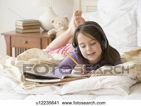 Girl listening to headphones and studying View Large Photo Image Stock Image - Girl listening to headphones and studying. Fotosearch