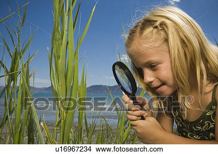 Picture - Girl looking through magnifying glass, Utah, United States. Fotosearch