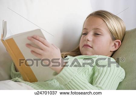 Stock Photo - Girl reading on sofa. Fotosearch