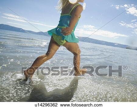 Stock Image - Girl running in water, Utah, United States. Fotosearch
