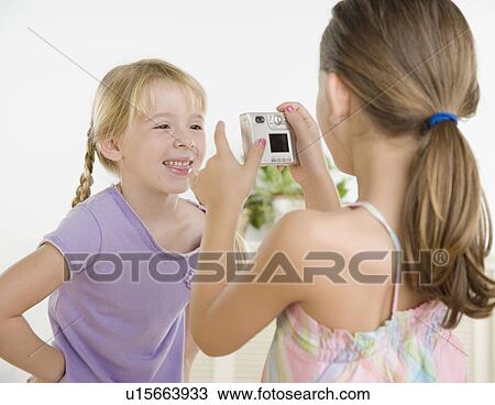 Girl taking photograph of sister View Large Photo Image Stock Image - Girl taking photograph of sister. Fotosearch