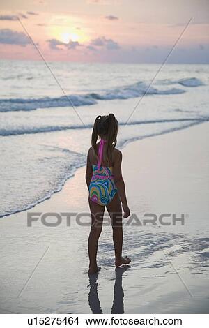 Girl walking on beach at sunset, Florida, United States View Large Photo Image Picture - Girl walking on beach at sunset, Florida, United States. Fotosearch