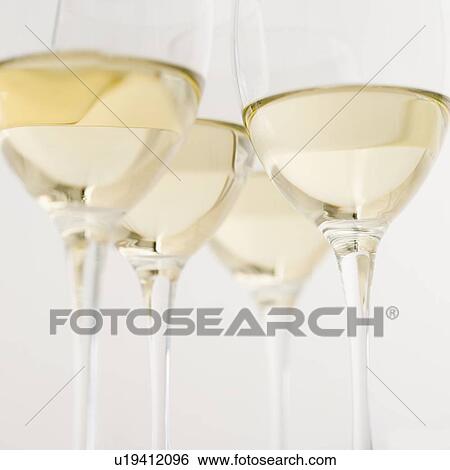 Glasses of white wine seen from below View Large Photo Image Stock Photograph - Glasses of white wine seen from below. Fotosearch