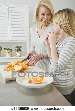 Grandmother and granddaughter cutting oranges View Large Photo Image Stock Photo - Grandmother and granddaughter cutting oranges. Fotosearch