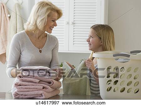 Grandmother and granddaughter folding laundry View Large Photo Image Stock Photo - Grandmother and granddaughter folding laundry. Fotosearch