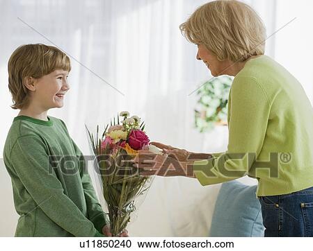 Grandson giving flowers to grandmother View Large Photo Image Stock Image - Grandson giving flowers to grandmother. Fotosearch