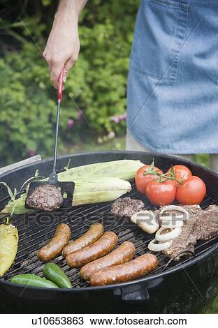 Grilling food outdoors in summer View Large Photo Image Stock Image - Grilling food outdoors in summer. Fotosearch