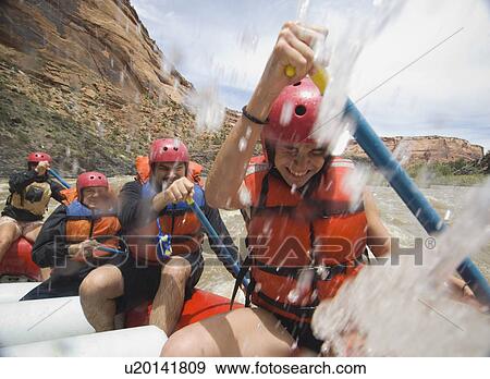 Stock Photo - Group of people paddling in raft. Fotosearch