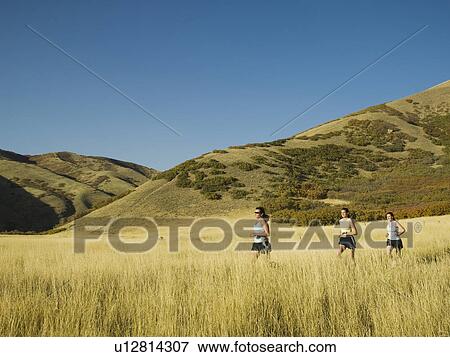 Group of people running in field, Utah, United States View Large Photo Image Stock Photo - Group of people running in field, Utah, United States. Fotosearch