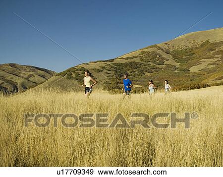 Stock Photo - Group of people running in field, Utah, United States. Fotosearch