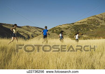 Stock Photograph - Group of people running in field, Utah, United States. Fotosearch