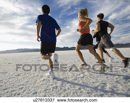 Stock Photo - Group of people running on salt flats, Utah, United States. Fotosearch