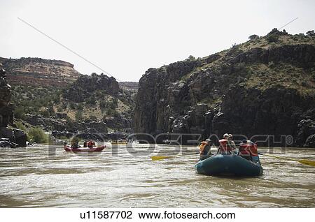 Stock Image - Groups of people river rafting. Fotosearch