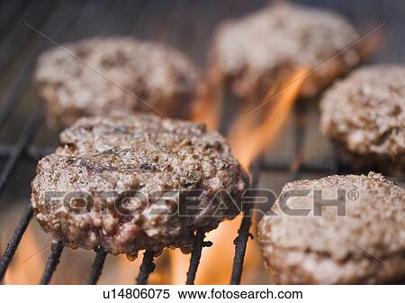 Stock Photography - Hamburger patties cooking on grill. Fotosearch
