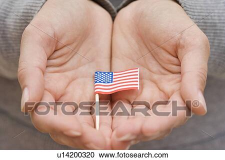 Stock Image - Hands holding small US flag. Fotosearch