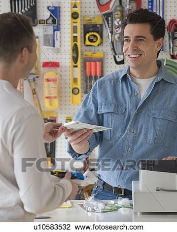 Hardware store sales clerk handing over purchase View Large Photo Image Stock Image - Hardware store sales clerk handing over purchase. Fotosearch