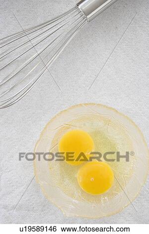 Stock Photograph - High angle view of whisk next to eggs in bowl. Fotosearch