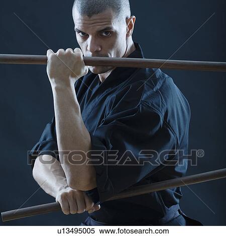 Hispanic male holding sticks in fighting stance View Large Photo Image Stock Photography - Hispanic male holding sticks in fighting stance. Fotosearch