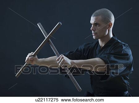 Hispanic male holding sticks in fighting stance View Large Photo Image Stock Photography - Hispanic male holding sticks in fighting stance. Fotosearch