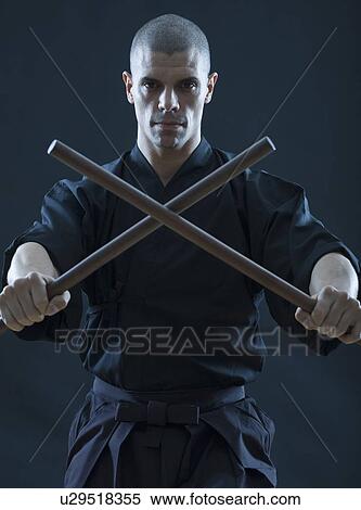 Hispanic male holding sticks in fighting stance View Large Photo Image Stock Photography - Hispanic male holding sticks in fighting stance. Fotosearch