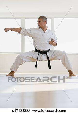 Stock Image - Hispanic male karate black belt in fighting stance. Fotosearch