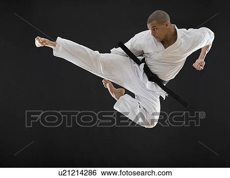 Hispanic male karate black belt kicking in air View Large Photo Image Stock Photograph - Hispanic male karate black belt kicking in air. Fotosearch