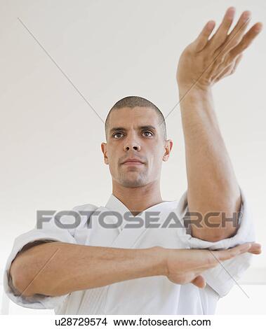 Picture - Hispanic man in karate fighting stance. Fotosearch