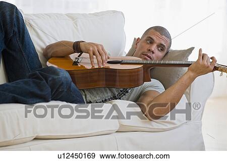 Stock Photo - Hispanic man playing guitar. Fotosearch