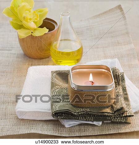 Lit candle in front of flower and bath oil View Large Photo Image Stock Image - Lit candle in front of flower and bath oil. Fotosearch