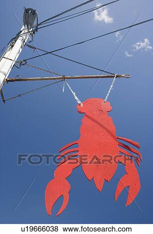 Stock Photo - Lobster shaped sign under blue sky, Maine, United States. Fotosearch