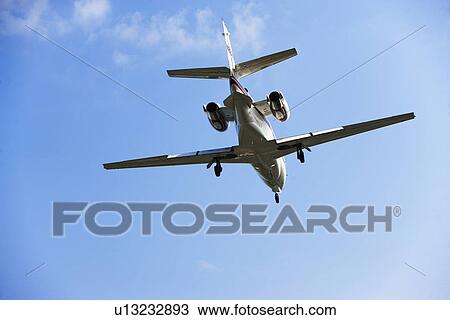 Low angle view of airplane in flight View Large Photo Image Stock Image - Low angle view of airplane in flight. Fotosearch