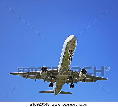 Stock Photo - Low angle view of airplane in flight. Fotosearch