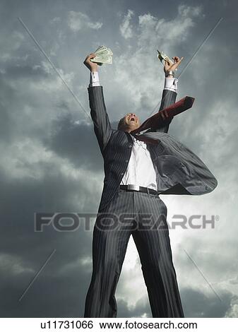 Stock Photograph - Low angle view of businessman cheering. Fotosearch