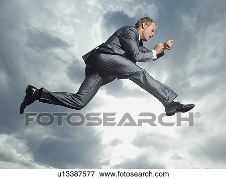 Low angle view of businessman jumping View Large Photo Image Stock Photo - Low angle view of businessman jumping. Fotosearch