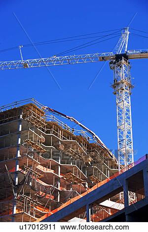 Stock Image - Low angle view of construction site and crane. Fotosearch