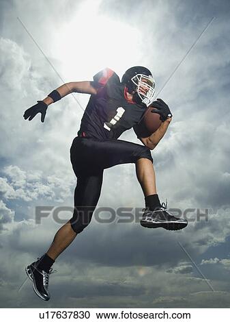 Low angle view of football player jumping View Large Photo Image Stock Image - Low angle view of football player jumping. Fotosearch
