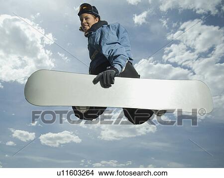 Low angle view of snowboarder jumping View Large Photo Image Picture - Low angle view of snowboarder jumping. Fotosearch