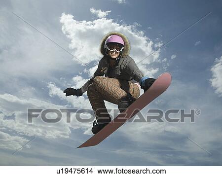 Picture - Low angle view of snowboarder jumping. Fotosearch
