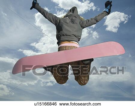 Stock Photograph - Low angle view of snowboarder jumping. Fotosearch