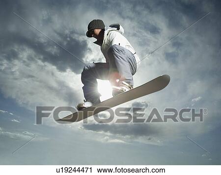 Stock Image - Low angle view of snowboarder. Fotosearch