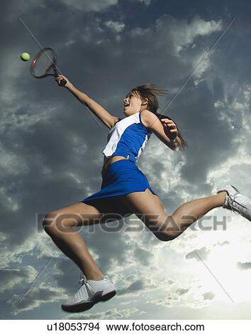Picture - Low angle view of tennis player jumping. Fotosearch