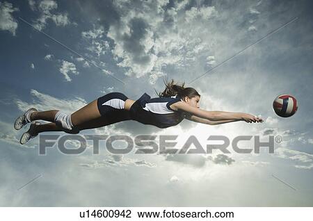 Stock Image - Low angle view of volleyball player jumping. Fotosearch