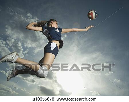 Stock Photo - Low angle view of volleyball player jumping. Fotosearch