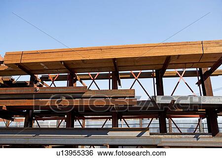 Stock Photograph - Lumber and metal stacked at construction site. Fotosearch
